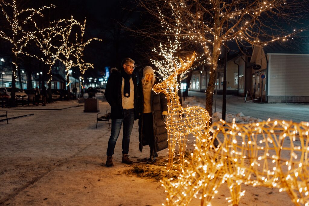 A couple looking at christmas light artworks in Savilanpuisto