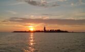 Sun setting behind the Kylmäpihlaja lighthouse island as seen from sea