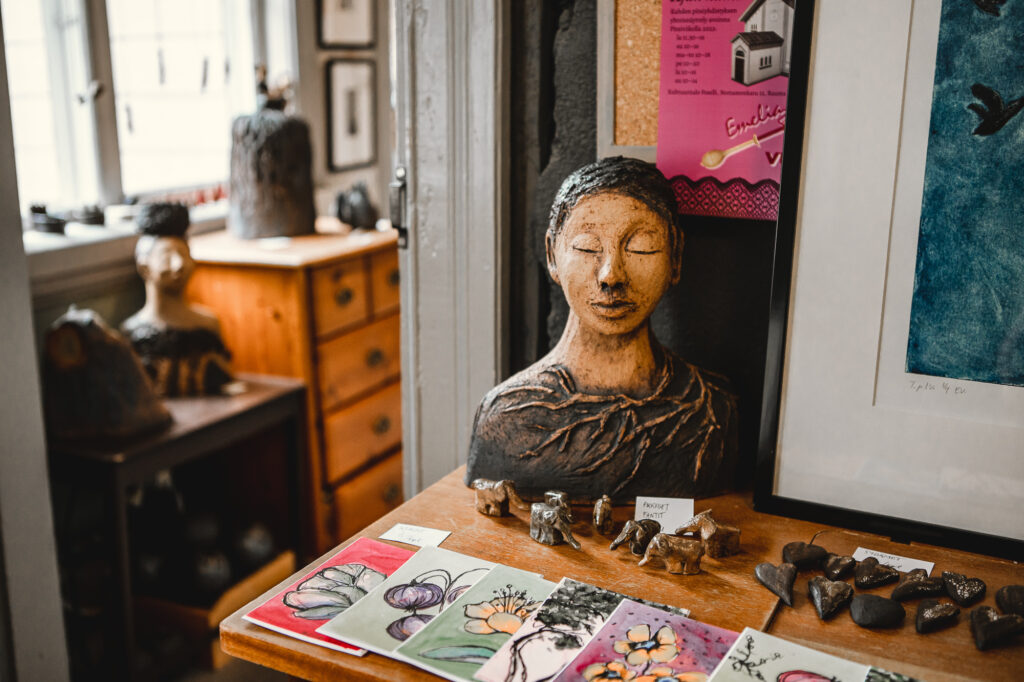 An artists workroom, with some artworks including a statue of a person and watercolor paintings