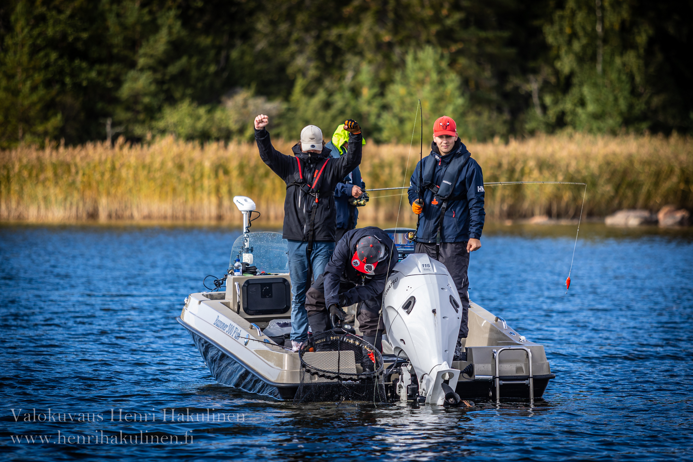 Four people on a boat fishing.