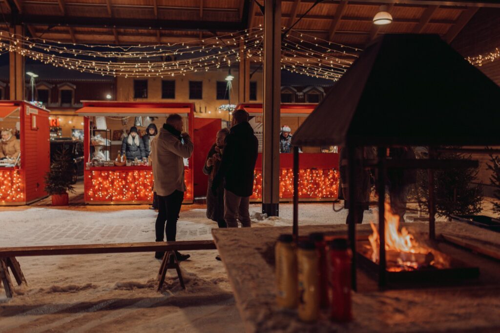 People at the Rauma Christmas Market. Fireplace in the foreground.