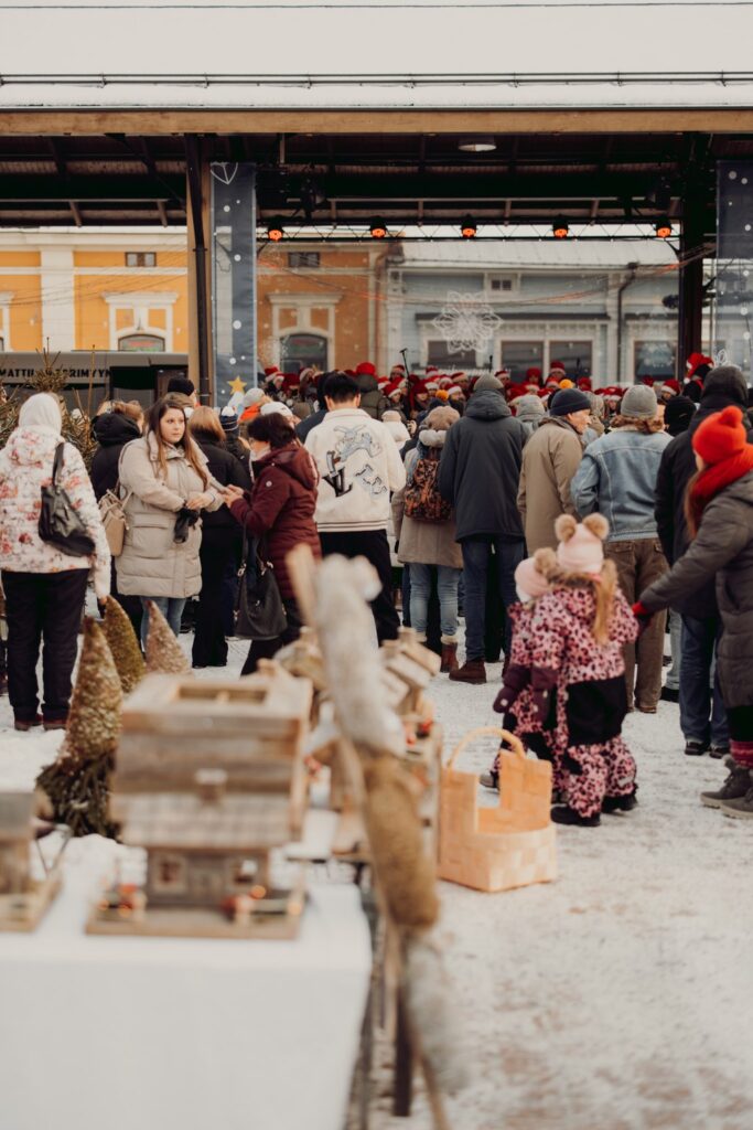 Crowds at the Rauma Christmas Market. Sales table and products in the foreground.