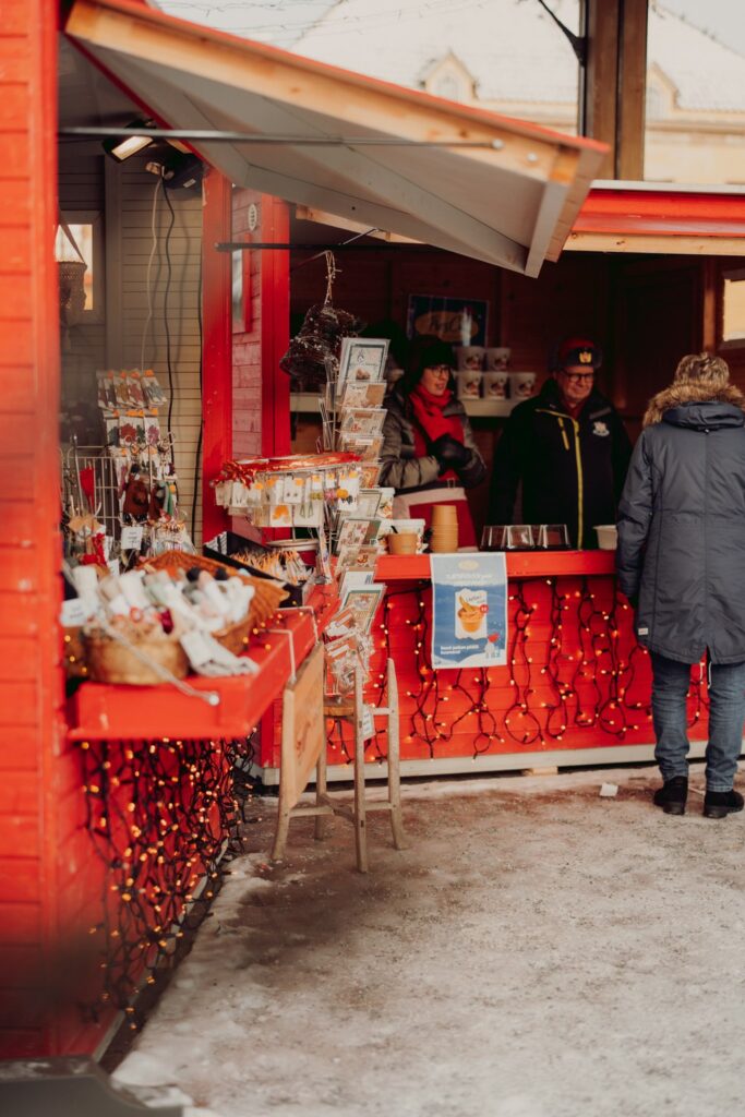 Christmas market booths in Rauma, a customer visiting a booth.