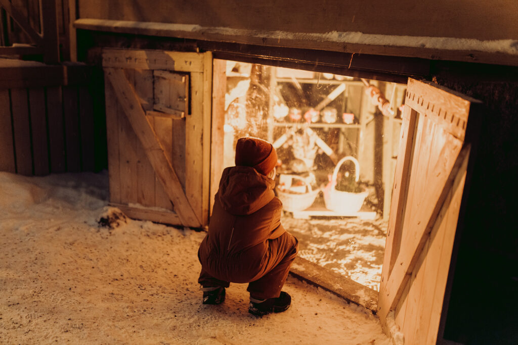 A child looking at the food cellar in The Christmas Elf Courtyard in Tammela.