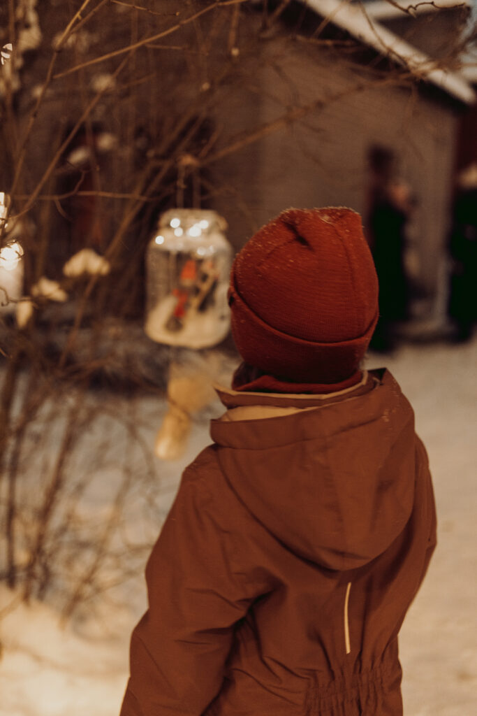 A child looking at an elf decoration.