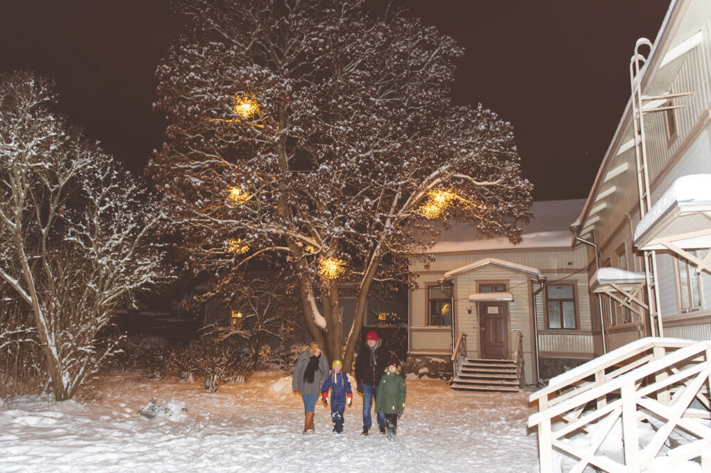 Perhe kävelemässä talvisessa Tammelan tonttumaassa.