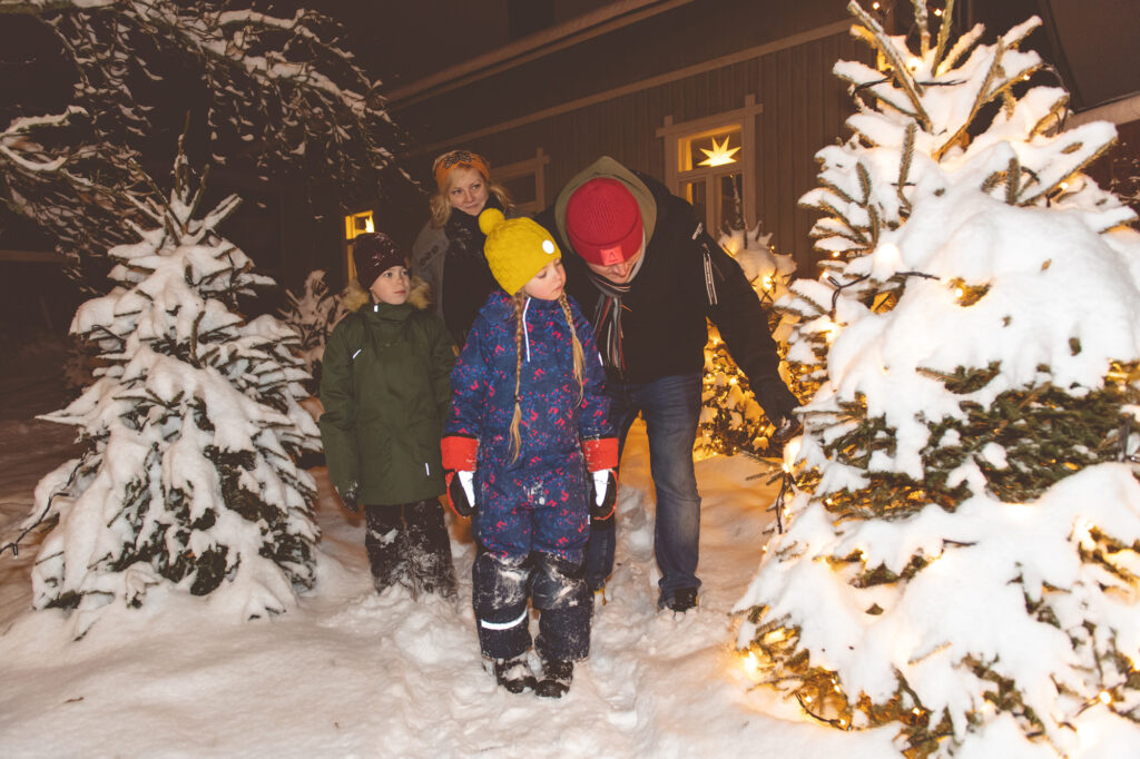 Perhe lumisessa Tammelan pihapiirissä.