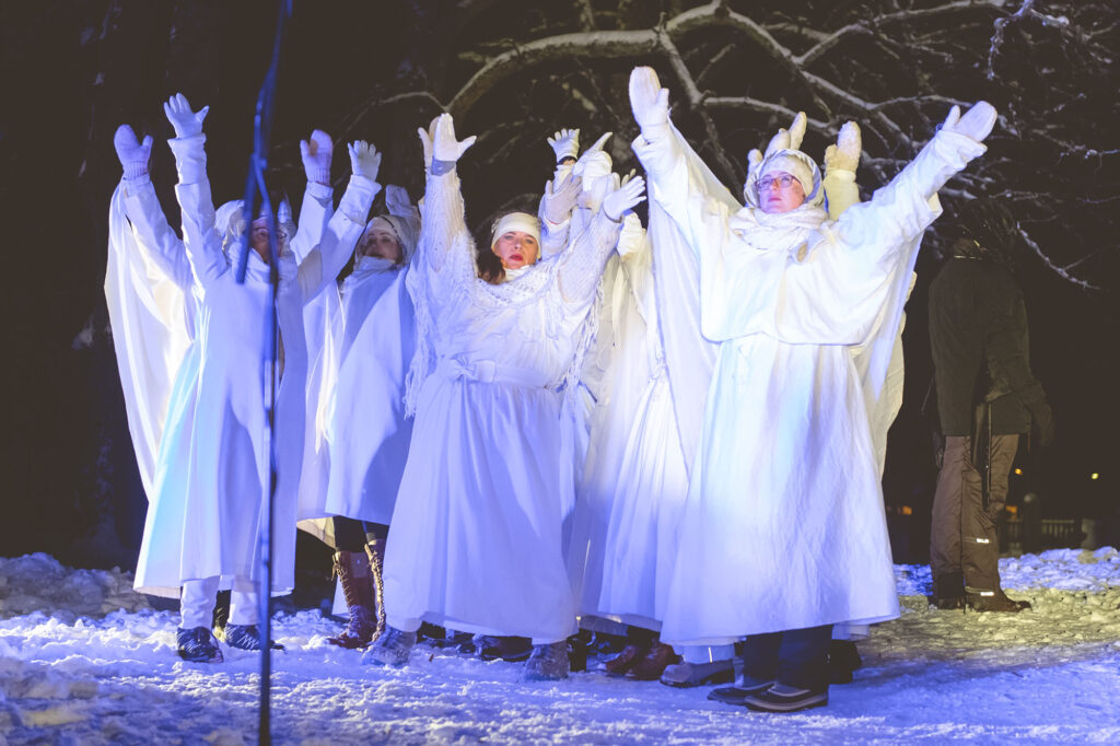 Valkoiset enkelit esiintymässä Pyhän Kolminaisuuden kirkon raunioilla Joulevangeeljum-musiikkinäytelmässä.