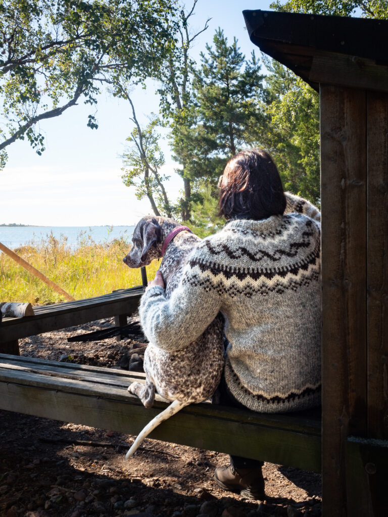 A woman and a dog on an island.