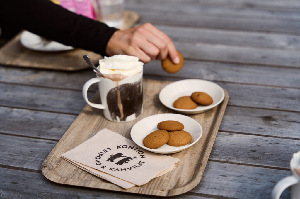 A coffee cup and two plates with Rauma cookies on a tray.