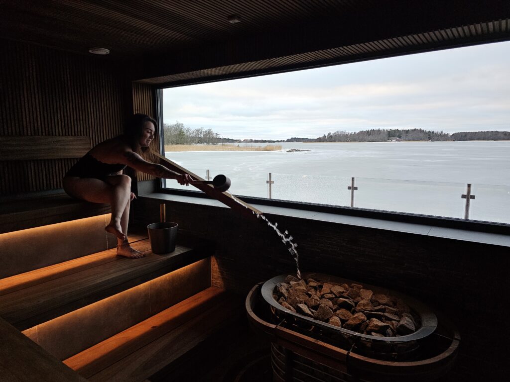 A person throwing water on the sauna stones in Marina Vista's sauna.